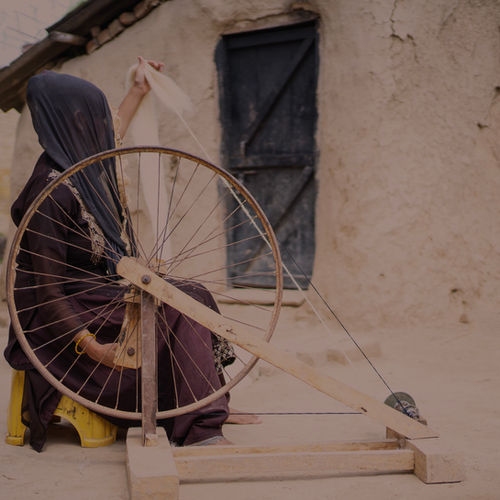 Artisan spinning yarn on a traditional charkha