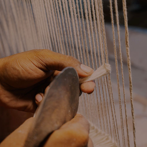 Tying yarn by hand on a rug loom